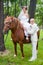 A groom and fiancee sit on a horse