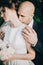 Groom gently kissing gorgeous bride on neck in sunset light. Portraits of beautiful tender wedding couple embracing in warm