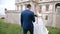 Groom gives bride bouquet of wedding flowers near the castle