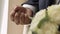 Groom in gray jacket holding wedding rings on palm of his hand, man clenched rings in his fist