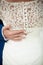 Groom hand on brides dress