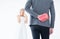 Groom hiding red gift box behind back in order to surprise bride on the wedding day,Woman positive emotion and face astonished hap