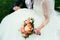Groom holding a bride hand with weding bouquet on wedding day