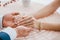 Groom holding bride\'s hands with ring at table