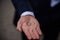 Groom holding wedding rings in hand. Two wedding rings on the floor with contrast wedding rings on floor, on ground, on piano, in