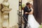 Groom holds bide`s face tender standing with her on the stairs o