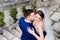 Groom holds bride tender standing on old stone footsteps