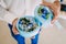 Groom holds a round box with Wedding rings with blue flowers. Artwork. Soft focus, Close-up