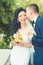 Groom kiss happy bride with bouquet. Woman and man smile on wedding day. Wedding couple in love. Newlywed couple on