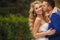 The groom kisses the bride in a green Park in the summer.