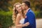 The groom kisses the bride in a green Park in the summer.