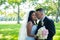 Groom kisses bride on her cheeks, Caucasian groom and Asian bride