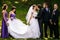 Groom kisses a bride while his friends grimaces behind him