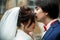 Groom kisses bride`s forehead while she stands with closed eyes