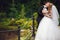 Groom kisses bride tenderly holding her waist while they stand o