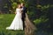 Groom kissing bride near fence in wood