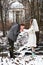 Groom kissing bride\'s hand in the winter woods