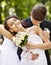 Groom kissing bride on shoulder .