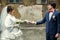 Groom looks with love at a bride holding her arm in a white glove