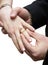 Groom placing ring on finger of bride