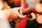 Groom puts bangle in bride hand at bangle ceremony with lights.