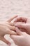 Groom puts ring on Bride - Beach Wedding