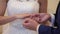 Groom puts on ring to bride hand on ceremony