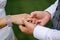 The groom puts a wedding ring on the bride hand, a beautiful wedding ceremony with fresh flowers, a beautiful girl and a