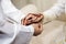 Groom putting on a gold chain into the hands of the bride