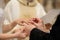 Groom putting a ring on bride\'s finger