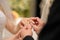 Groom putting a ring on bride\'s finger