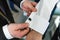 Groom`s friend helps fasten cufflinks on groom`s sleeve