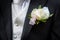 Groom\'s white boutonniere flower and suit details