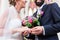 Groom slipping ring on finger of bride at wedding