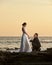 Groom stand on knee and hold bride hand