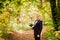 The groom stands in the autumn forest on a background of yellow leaves