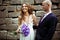 Groom stands behind a smiling bride