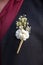 Groom in a suit with a boutonniere. Flower design, floristry. Wedding day and accessories