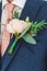 Groom in a suit with boutonniere. Flower design, floristry. Wedding day and accessories