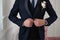 Groom in a suit with a tie fastens a button on his suit