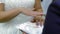 The groom takes the wedding ring from the pad and puts it on the bride`s finger