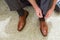 Groom tying his brown leather shoes