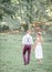 Groom in violet trousers walks with tender young bride