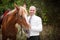 Groom during walk in their wedding day against a brown horse