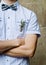 Groom in white shirt and bow tie his arms folded