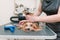 Groomer combing cute yorkshire terrier with comb on the table