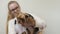 Groomer holds small yorkshire terrier on hands and combs his fur