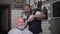 grooming hair with trimmer, modern retired male barber shop cutting hair and beard at popular barber while sitting in