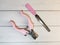 Grooming scissors with pink handles and emery board for pet on a light wooden background