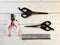 Grooming scissors with pink handles and pair of scissors for pet on a light wooden background